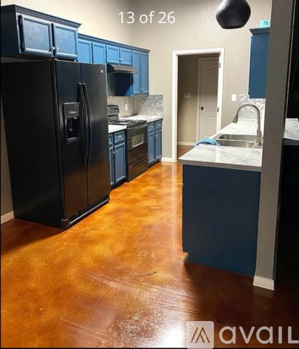 A kitchen with black appliances and blue cabinets.