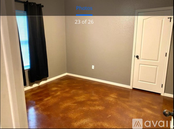 A room with a brown floor and a white door.