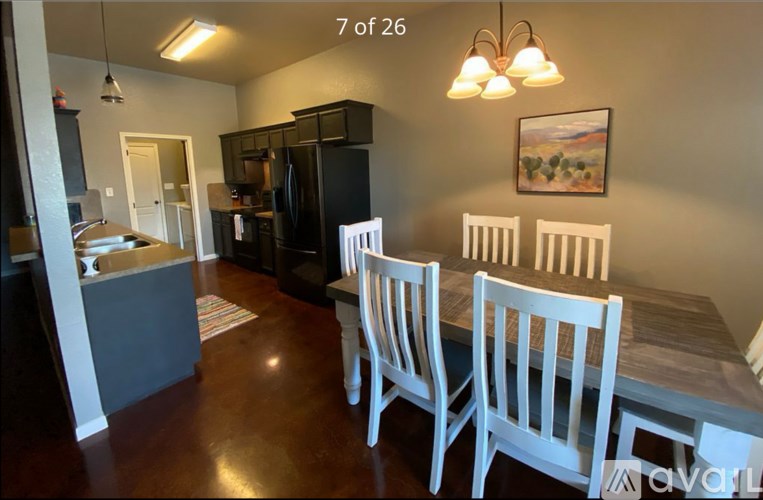 A kitchen with a dining table and chairs.