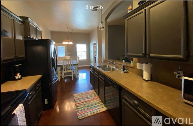 A kitchen with black appliances and wooden cabinets.