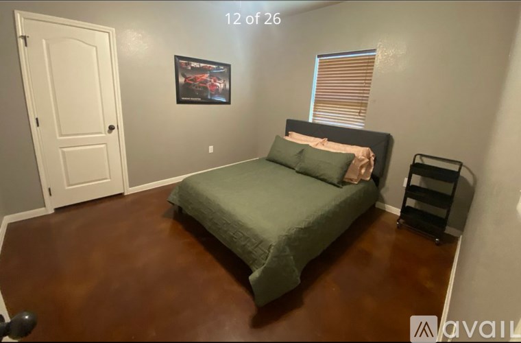 A bedroom with a bed, a picture on the wall, and a door.