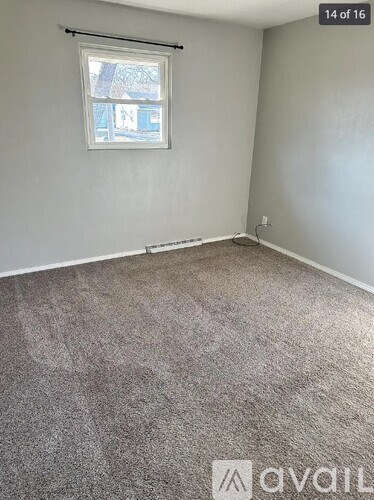A room with a carpeted floor and a window.