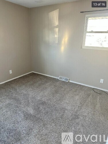A room with a carpeted floor and a window.