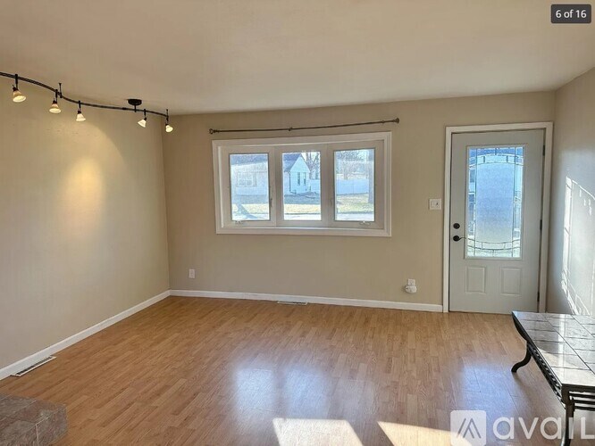 A room with a window and a door is available for rent.