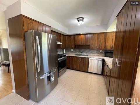 A kitchen with a large refrigerator and wooden cabinets.