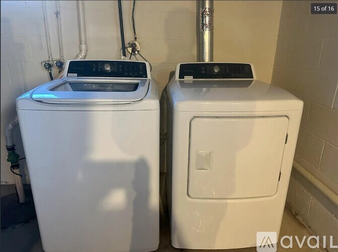 Two white front loading washing machines in a laundry room.
