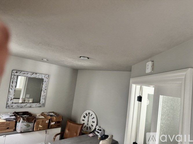 A room with a white ceiling and a mirror on the wall.