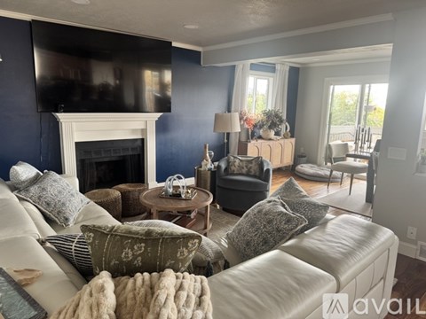A living room with a white couch and a fireplace.