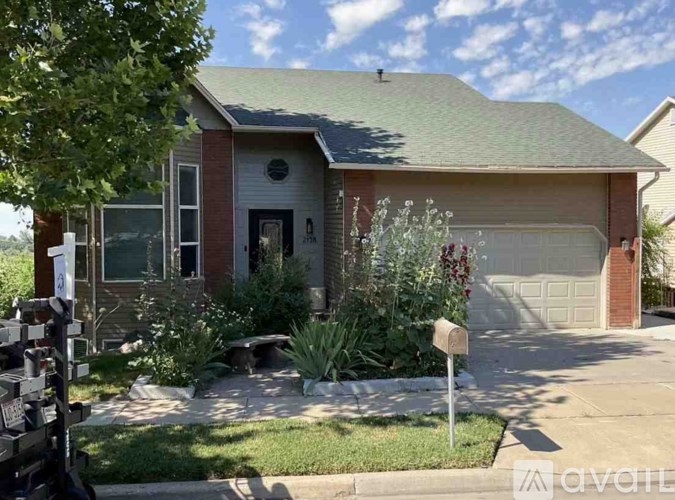 A house with a garage and a mailbox in front.