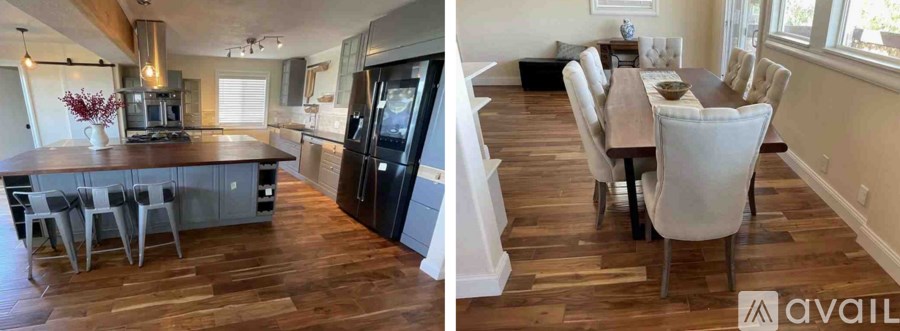 A modern kitchen with a large island and a dining area with a wooden table and chairs.