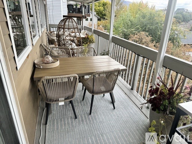 A balcony with a table and chairs overlooking a body of water.