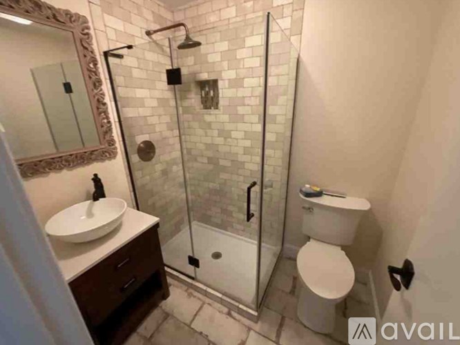 A bathroom with a white toilet, sink, and shower.
