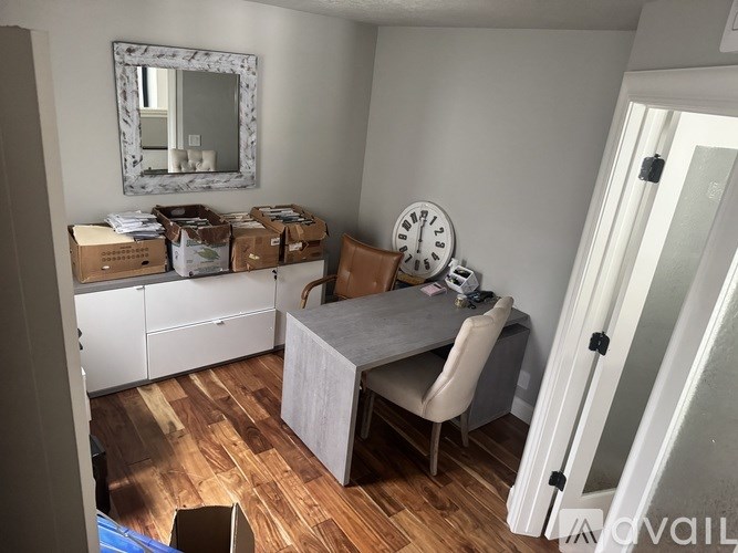 A room with a table and chairs and a mirror on the wall.