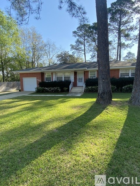 A house with a white door and a tree in front.