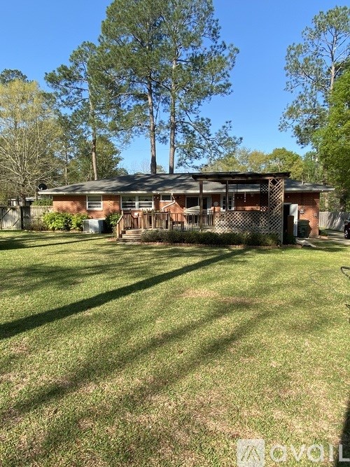 A house with a brown roof and a fence in front of it.