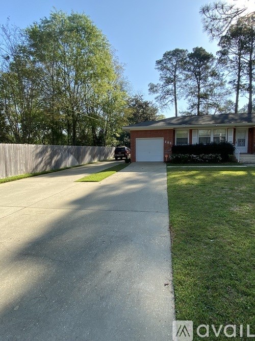 A house with a driveway and a car parked in front.