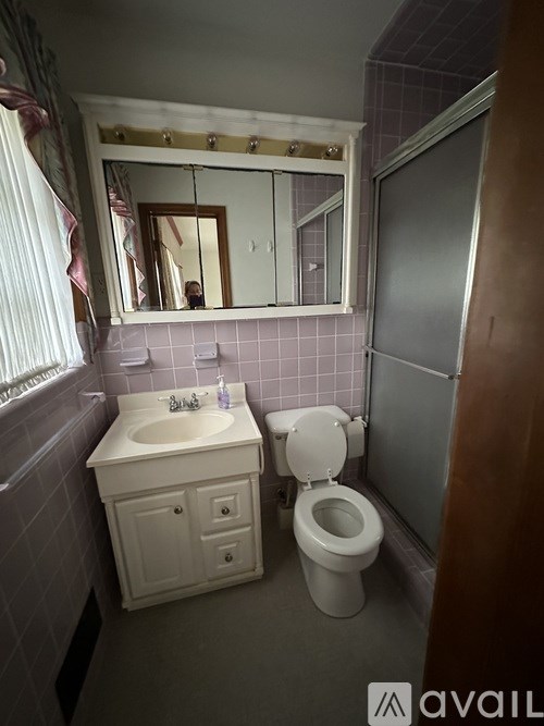 A bathroom with a sink, toilet and mirror.