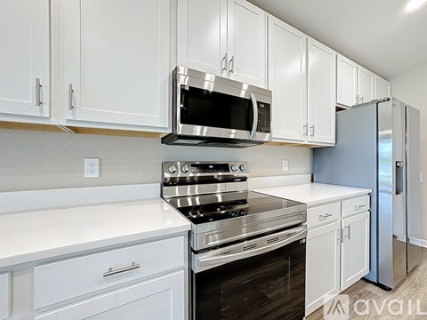 A kitchen with white cabinets and appliances.
