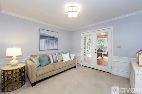 A living room with a beige couch, a lamp, and a painting on the wall.