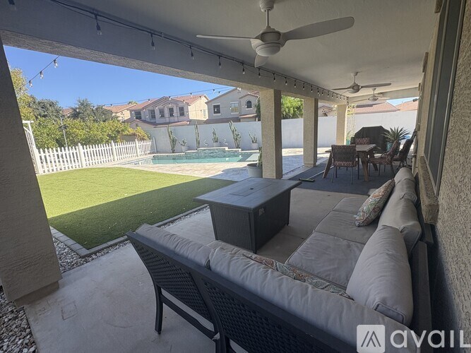 A patio with a couch, table, and fan.