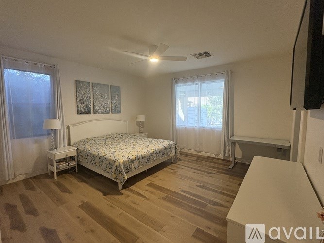 A bedroom with a bed, nightstand, and window.