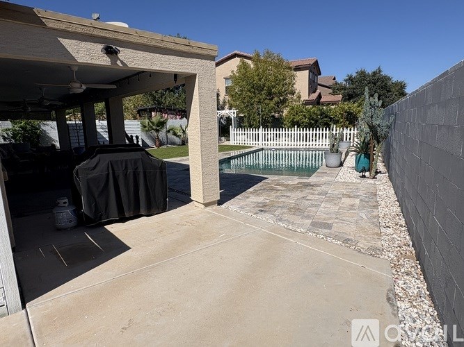 A patio area with a pool and a covered grill area.