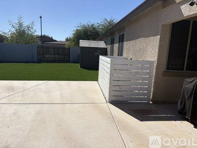 A white gate is open in front of a house.