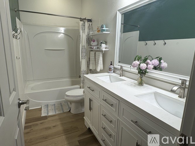 A bathroom with a white tub, sink, and toilet.