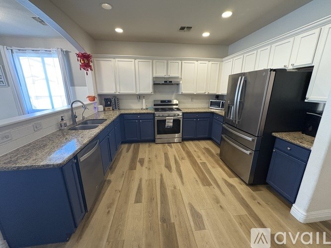 A kitchen with blue cabinets and wooden floors.
