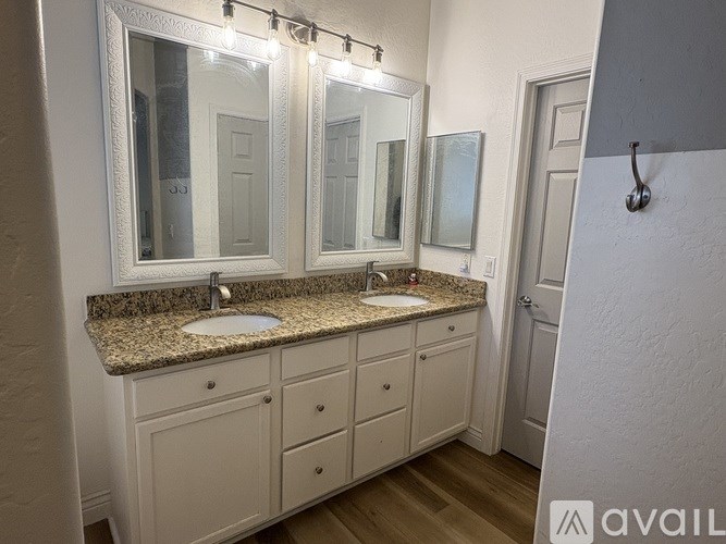 A bathroom with a granite countertop and a large mirror above the sink.