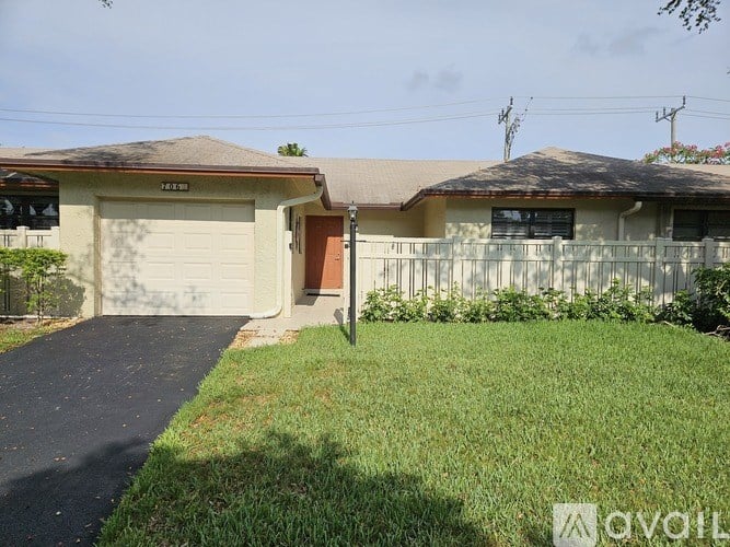 A house with a brown door and a white fence.