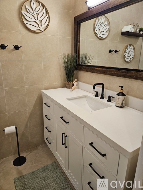 A bathroom with a white sink and a mirror above it.