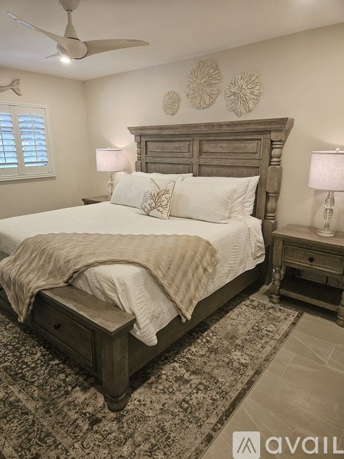 A bedroom with a large bed and a wooden headboard.