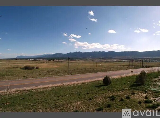 A road stretches into the distance with a mountain range in the background.