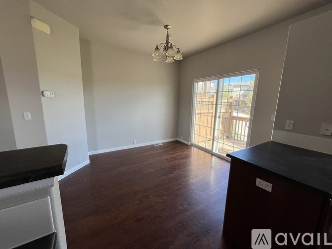 A room with wooden floors and a balcony with a railing.