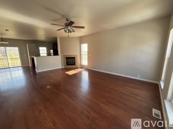 A spacious room with wood flooring and a ceiling fan.