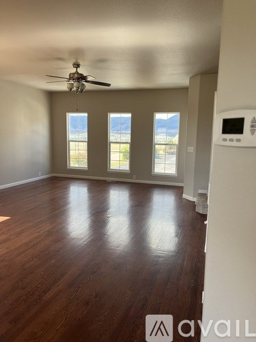 A room with wooden floors and a ceiling fan.