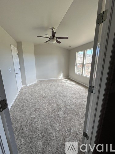 A room with a ceiling fan and carpeted floor.