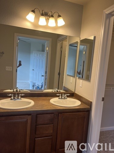 A bathroom with two sinks and a large mirror.