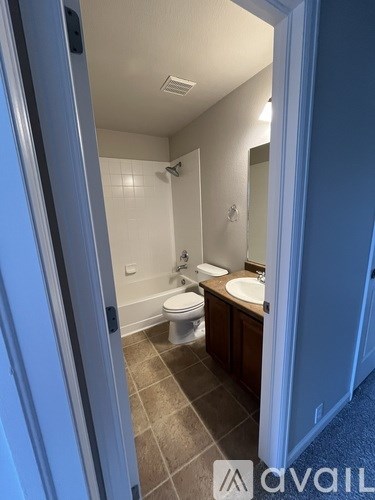 A bathroom with a toilet, sink, and mirror.
