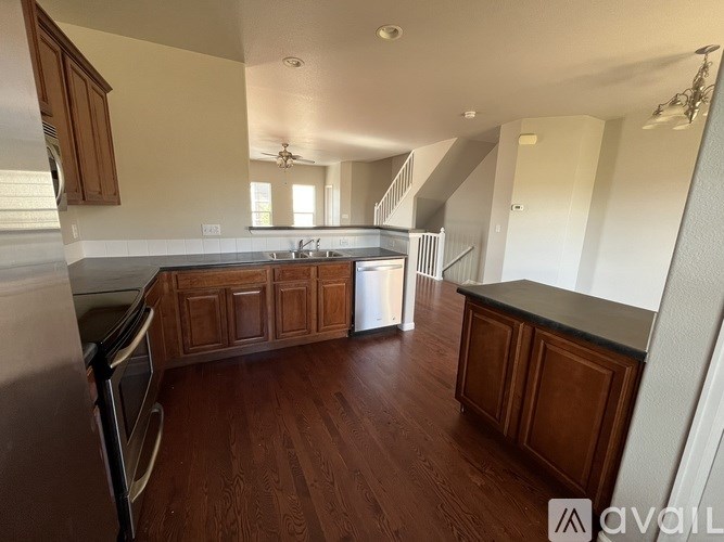 A kitchen with wooden cabinets and a stainless steel refrigerator.