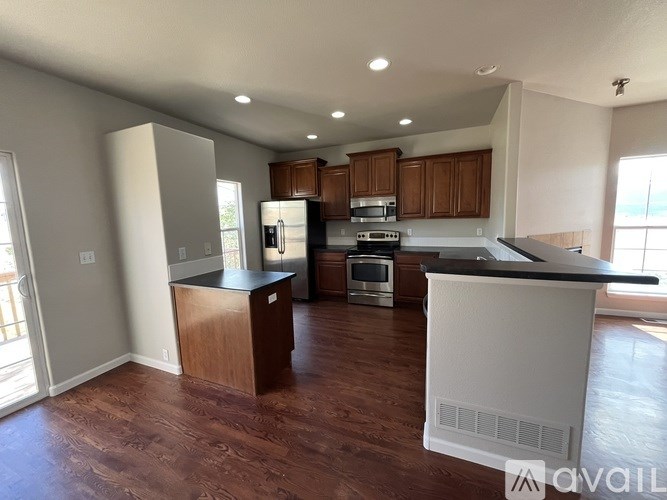A kitchen with wooden cabinets and a white island.