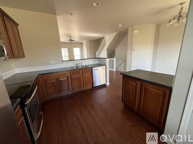 A kitchen with wooden cabinets and a stainless steel dishwasher.