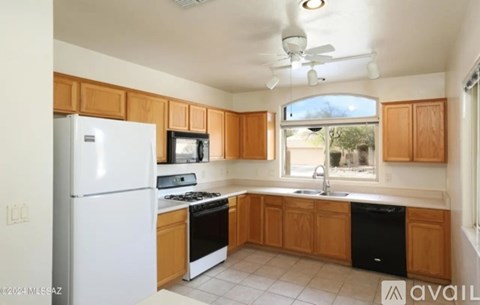 A kitchen with wooden cabinets and a white refrigerator.