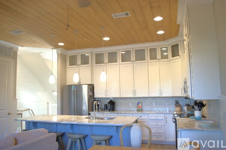 A kitchen with a blue island and white cabinets.