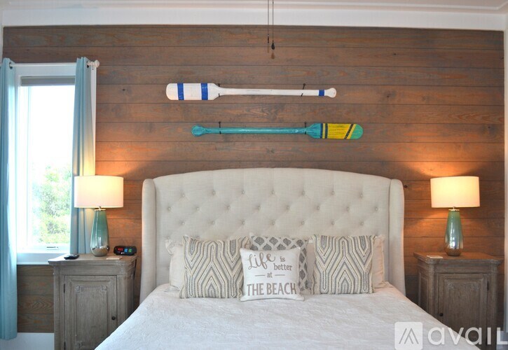 A bedroom with a white bed and wooden headboard.