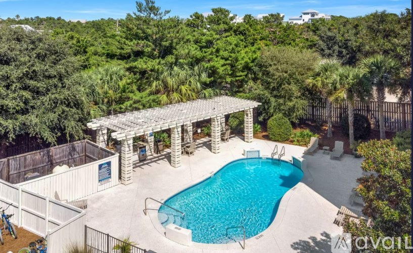 A pool with a pavilion and a fence around it.