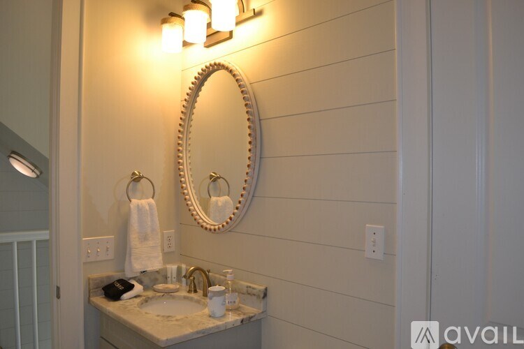 A bathroom with a round mirror and lights above it.