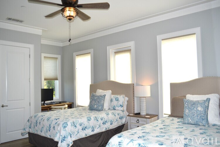 A bedroom with two beds and a ceiling fan.