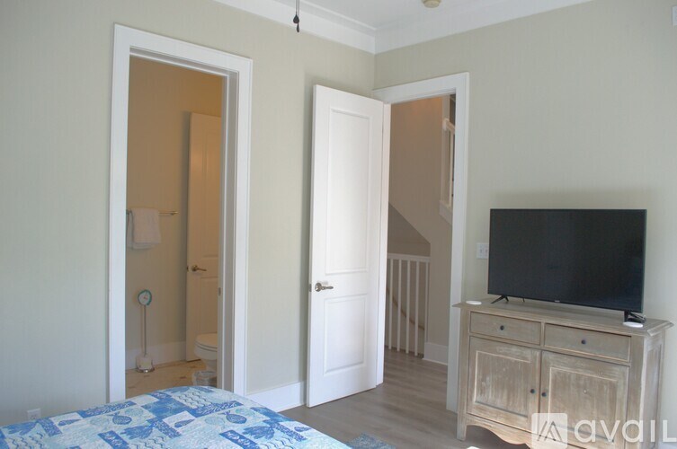 A bedroom with a bed, dresser and television.